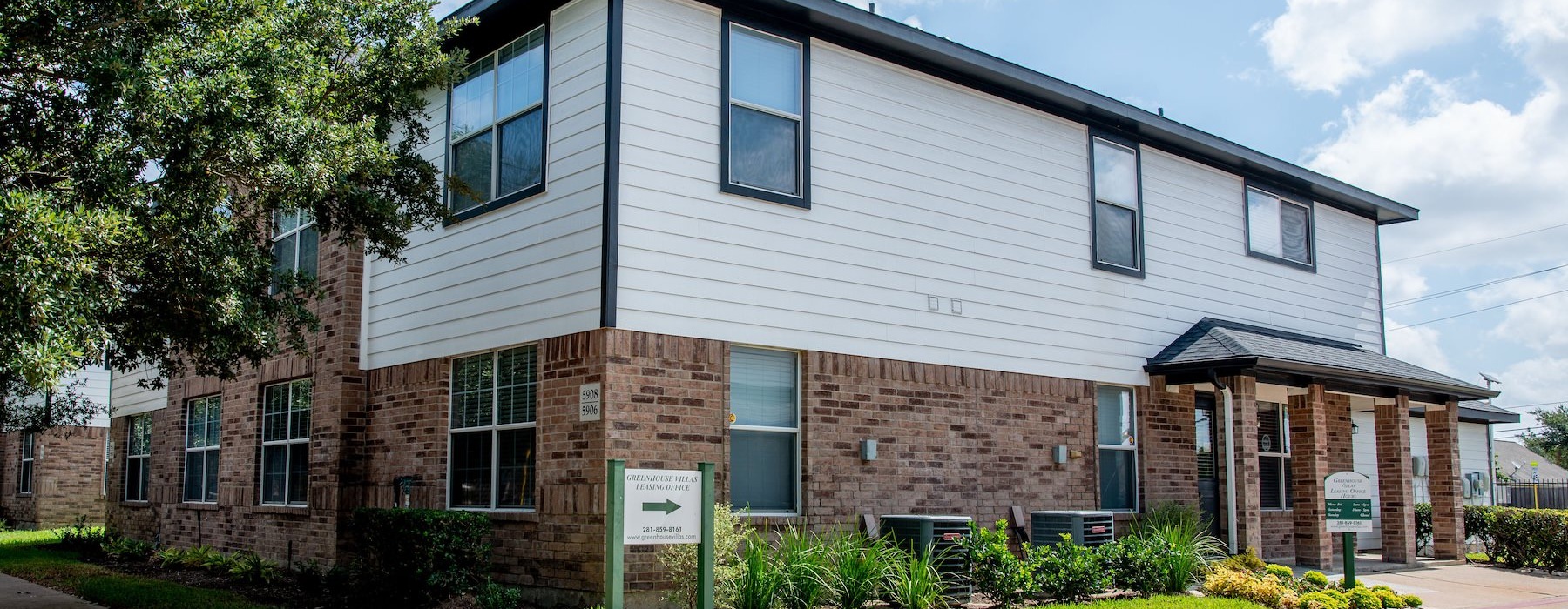 a brick building with a sign in front of it