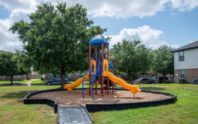 a playground with trees and grass