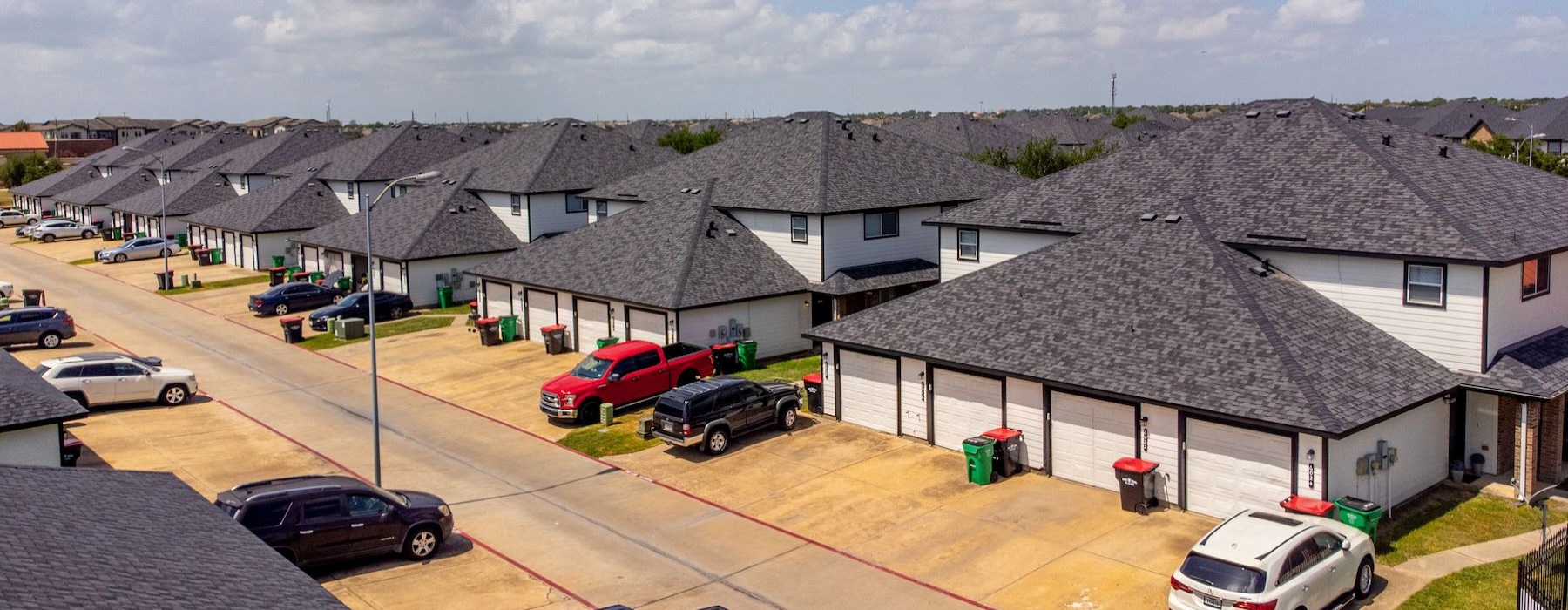 a group of houses with cars parked in front of them