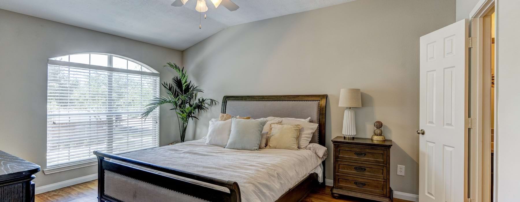 a bedroom with a bed and a plant