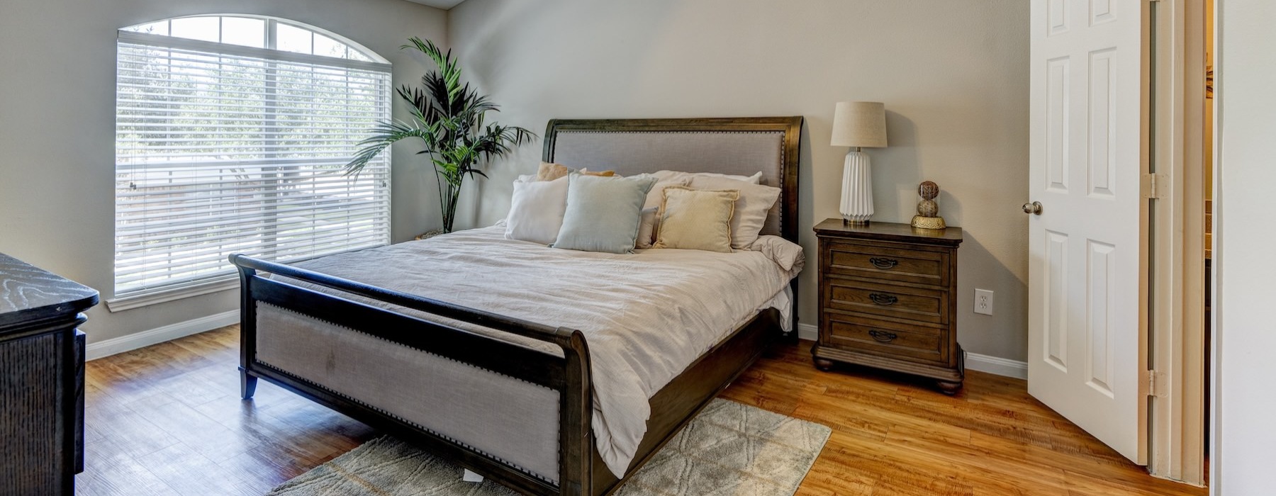 a bedroom with a bed and a plant